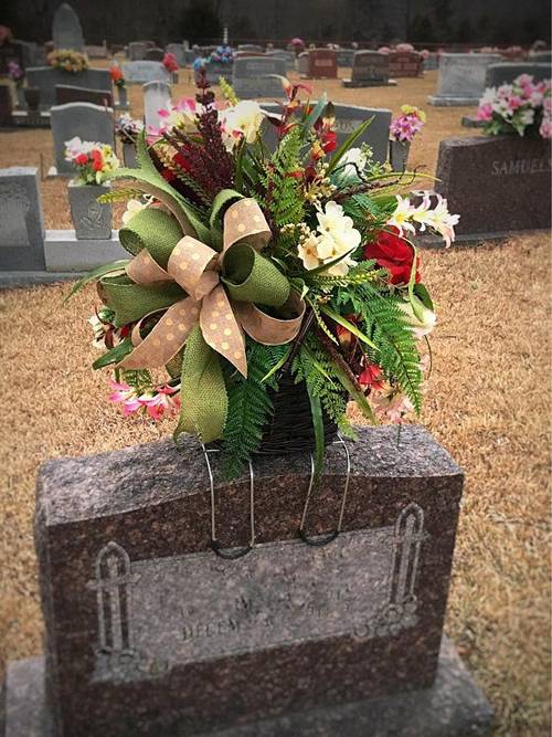 There is a fresh flower spray on the headstone.