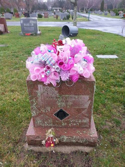 There is a pink flower spray on the headstone.