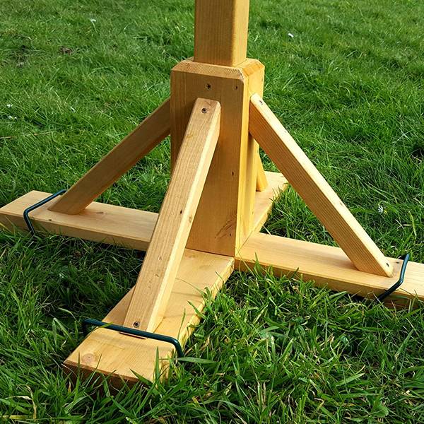 A square-based bird table is fixed with metal stabiliser pegs.