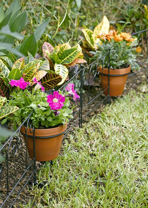 Flower pot holder with stakes for garden edging decor.